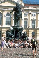 A class poses for a photo in front of a statue
