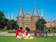 A family enjoy a picnic in front of the stunning Holsten Gate in Lbeck